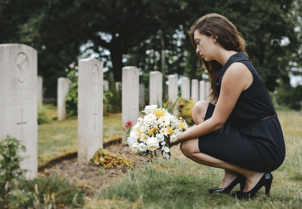 Insight Legal Solutions: young woman lays flowers at grave while preparing to take on the role of Executor for the Estate
