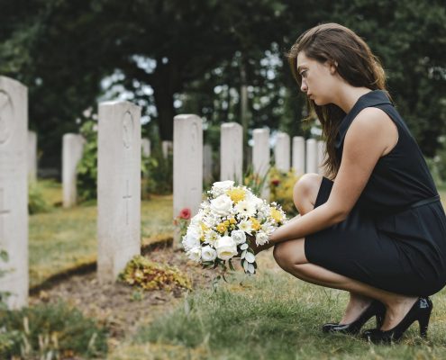 Insight Legal Solutions: young woman lays flowers at grave while preparing to take on the role of Executor for the Estate